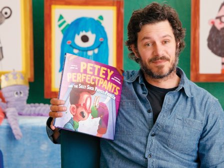 Adam Brody holding Petey Perfectpants on the Storyline Online set