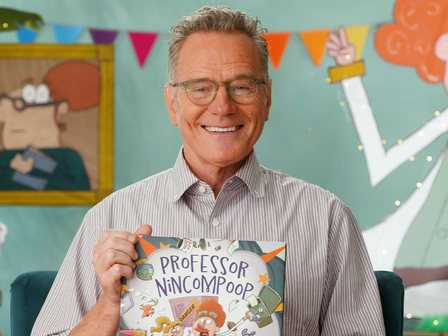 Bryan Cranston holding Professor Nincompoop on the Storyline Online set